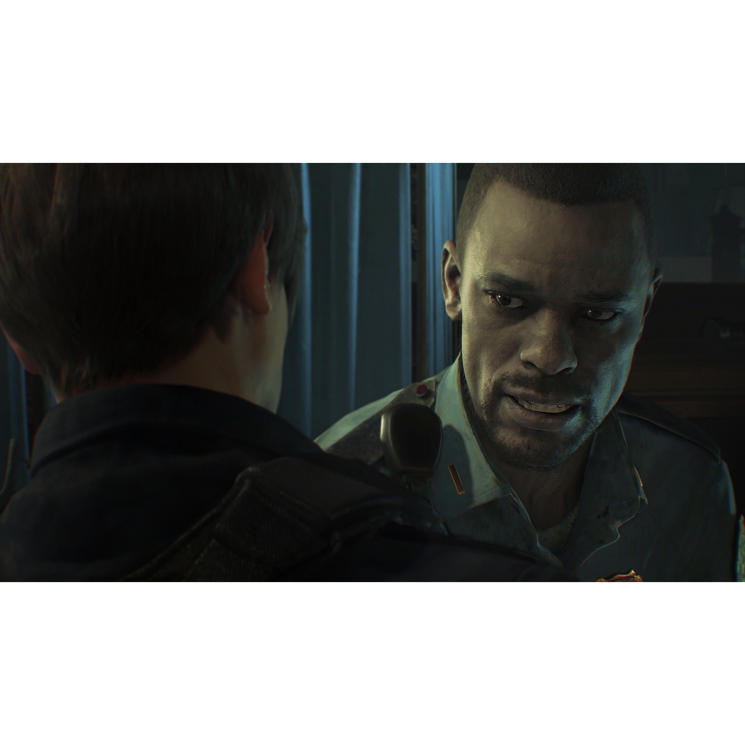 Two men are in a dark room, one is talking to the other.
