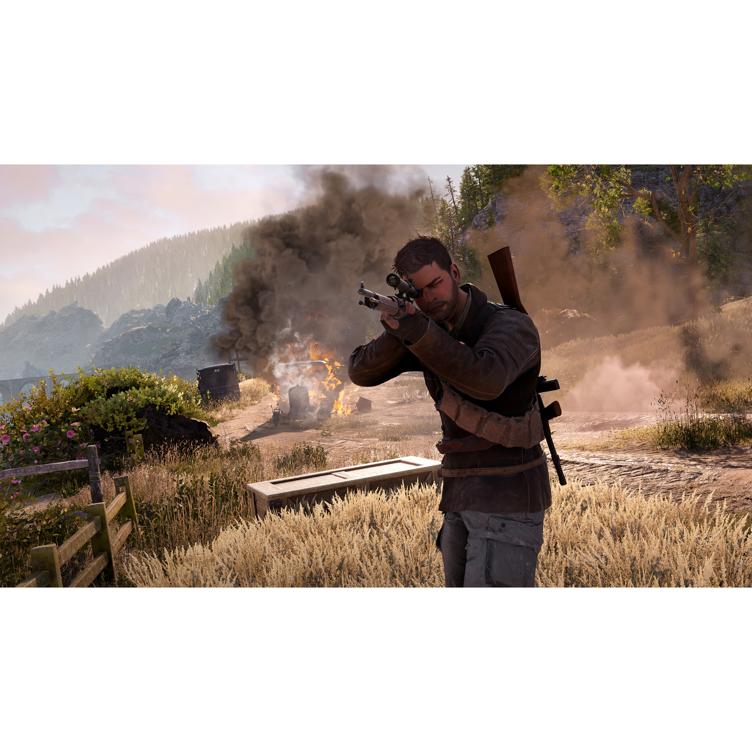 A man aiming a rifle at a burning structure in a grassy field, with a mountain backdrop.