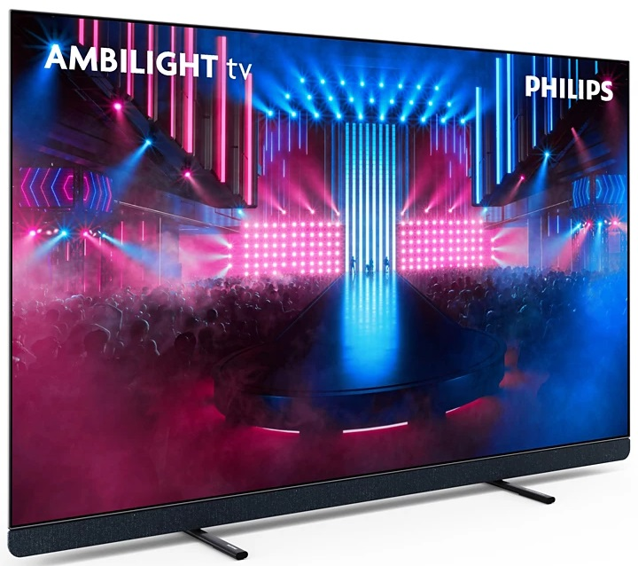 Duży telewizor pokazujący scenę ze światłami i ludźmi. Telewizor ma czarną ramkę z logo Ambilight.