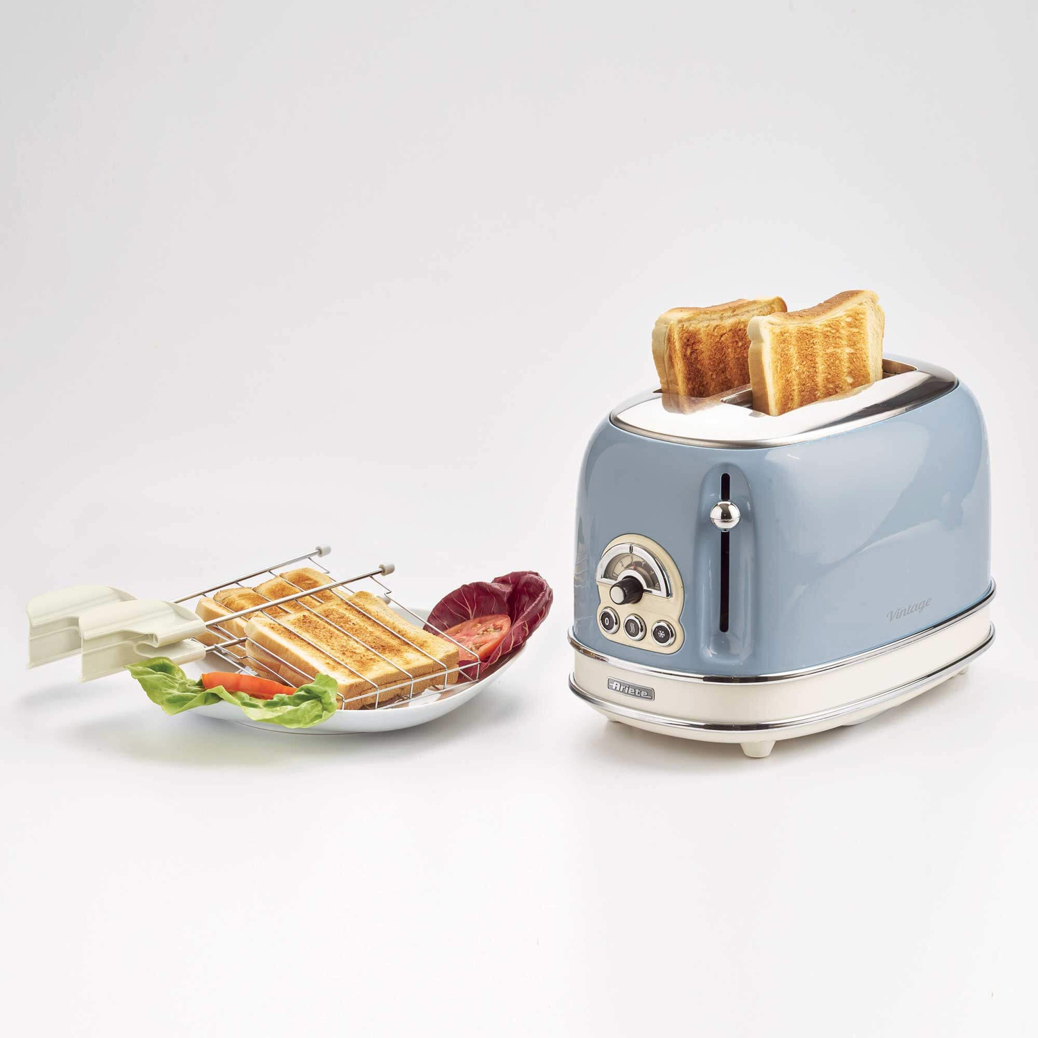 Tostapane con toast. Un piatto di toast e verdure è accanto.