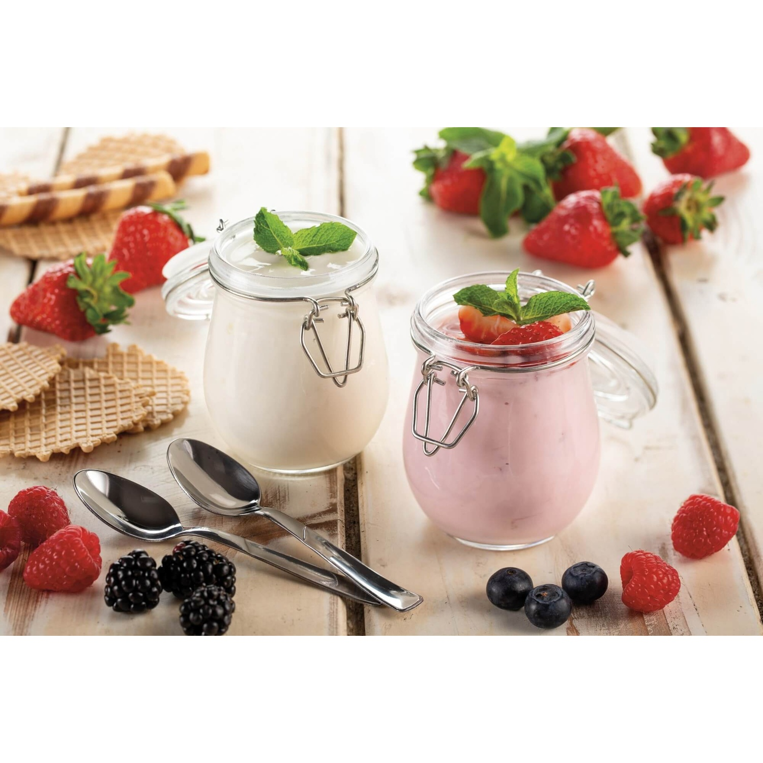 Due vasetti di yogurt con bacche e cucchiai.
