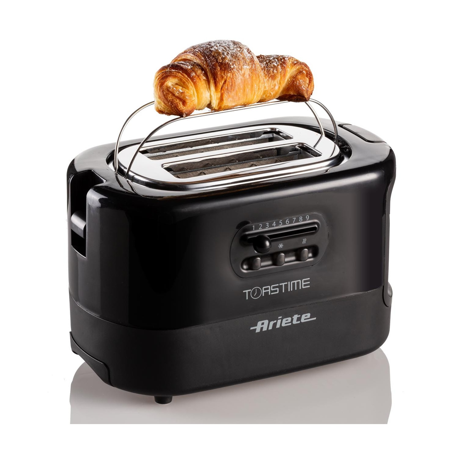 Tostapane nero con croissant sopra, su una superficie bianca.