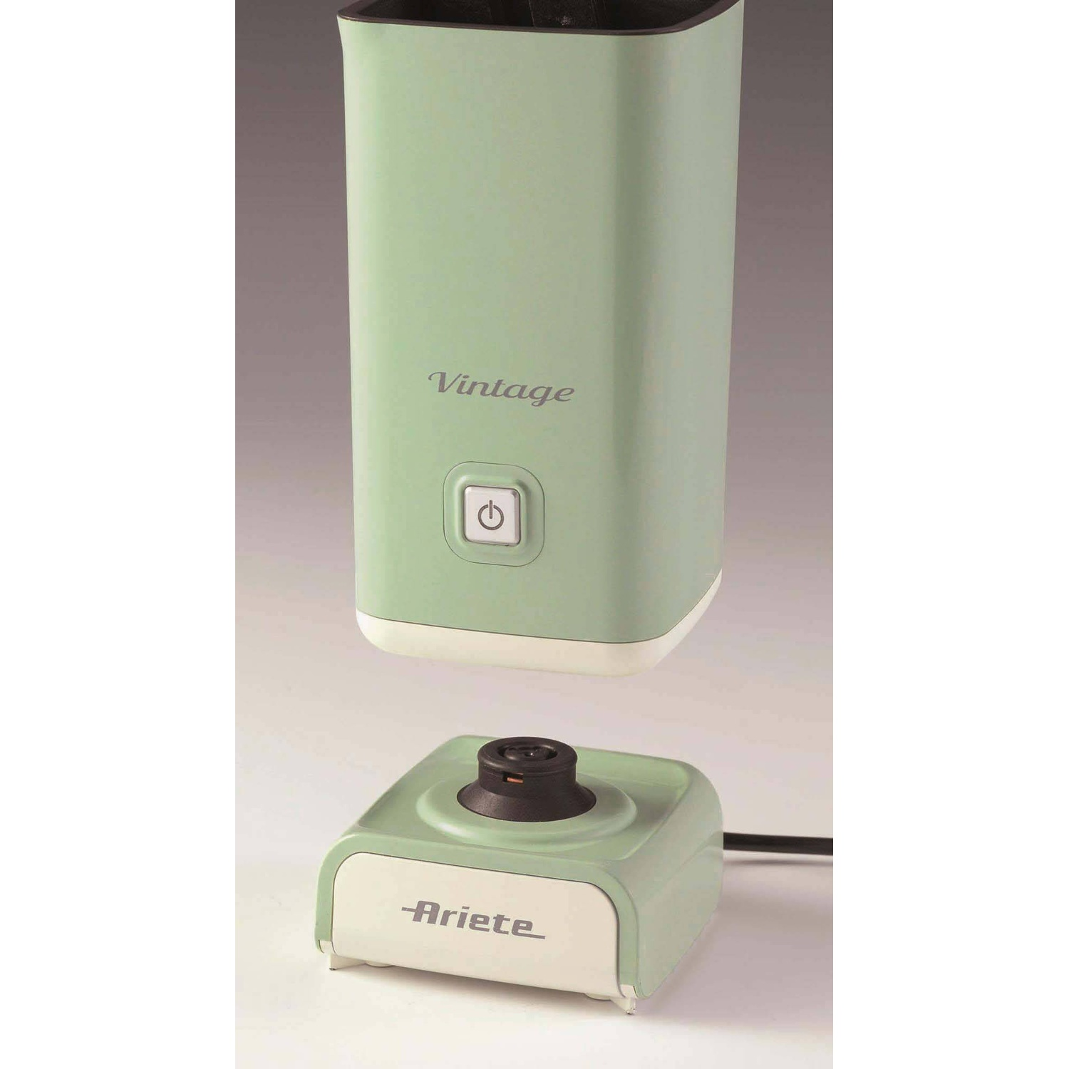 Un montalatte elettrico verde menta e bianco. La base è quadrata e il montalatte è cilindrico.