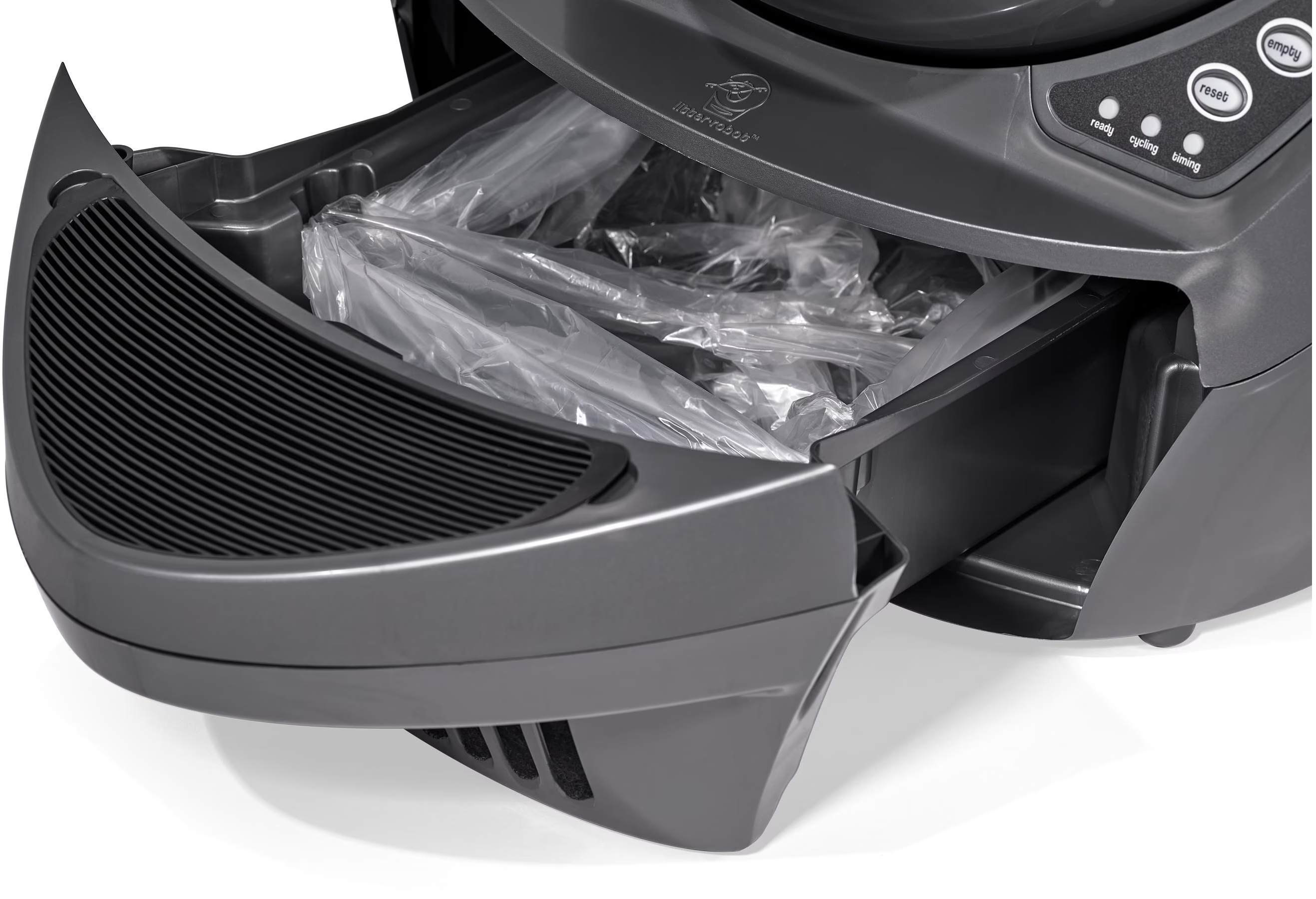 Un cassetto per lettiera grigio e aperto con sacchetti di plastica trasparenti all'interno, parte di una lettiera automatica.