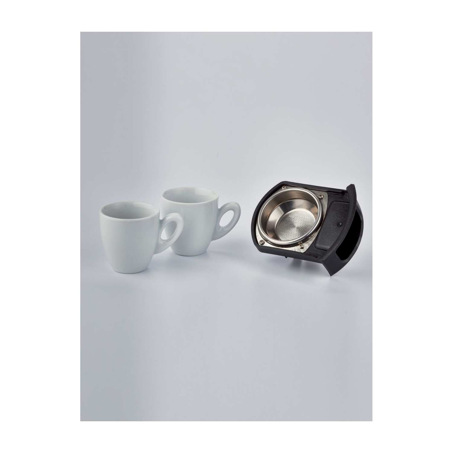 Due tazze da caffè bianche e un portafiltro.