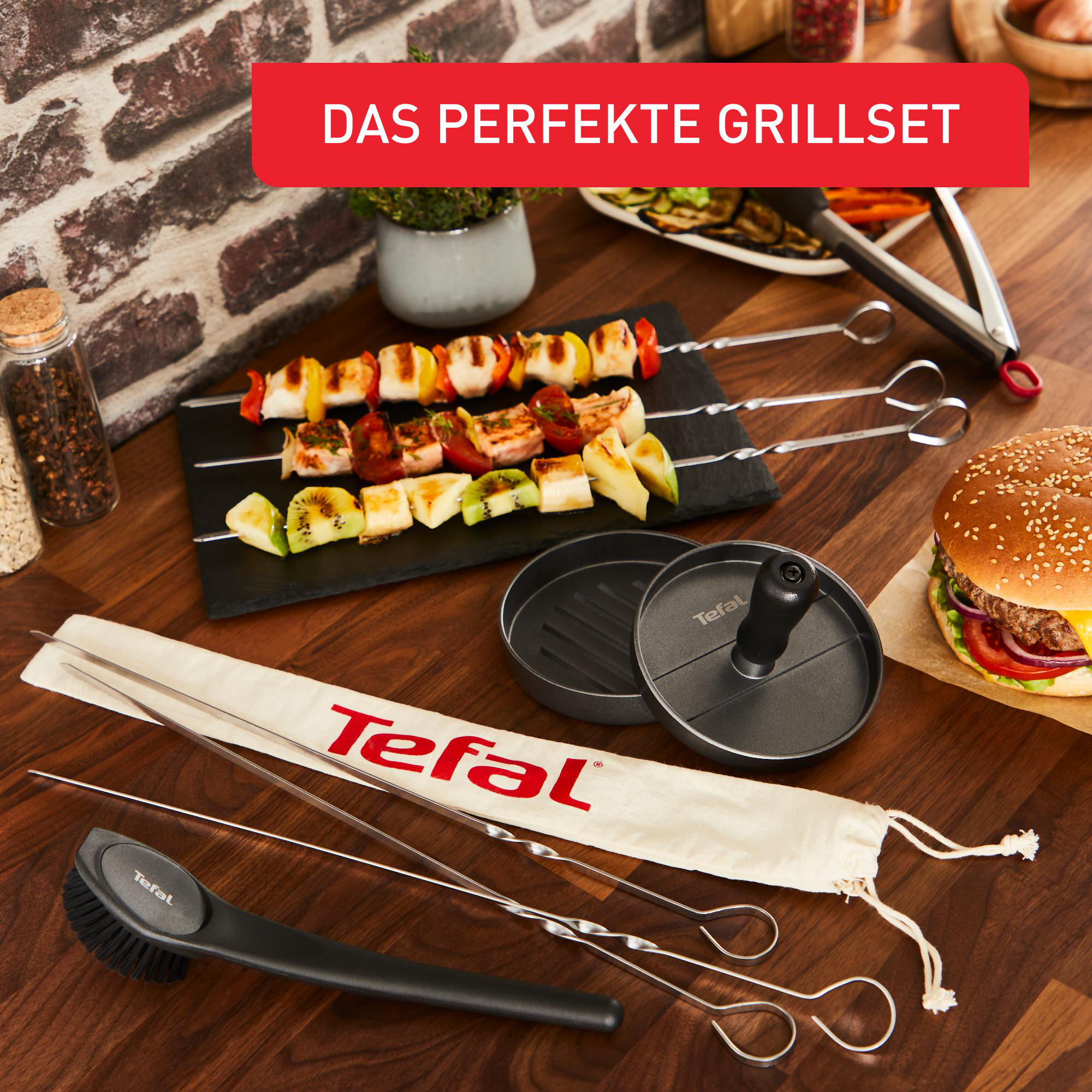 Grill-Set mit Spießen, Bürste und Burgerpresse auf Holz.