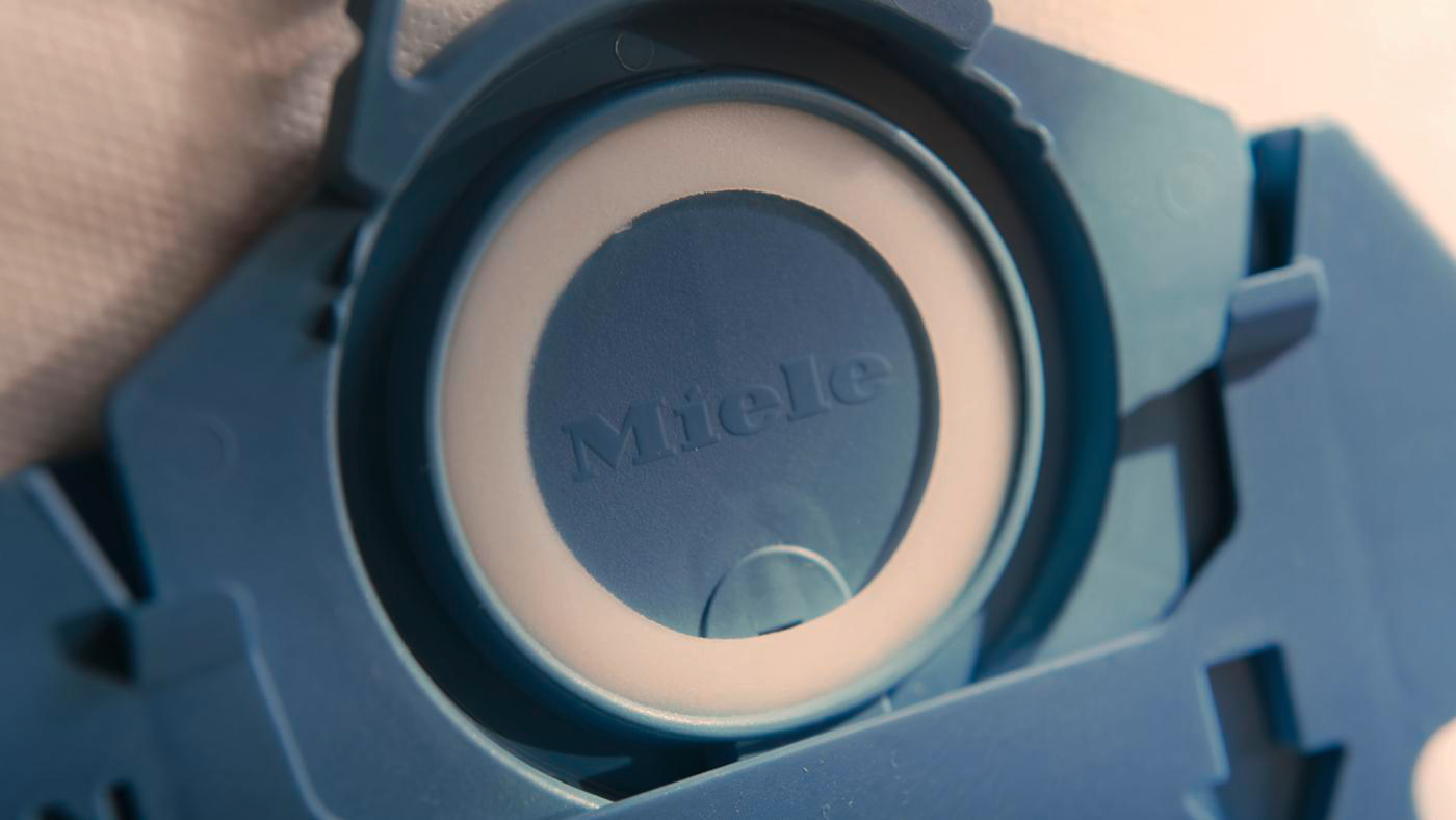 Nahaufnahme eines blauen Miele Staubsaugerbeutels mit Markennamen.