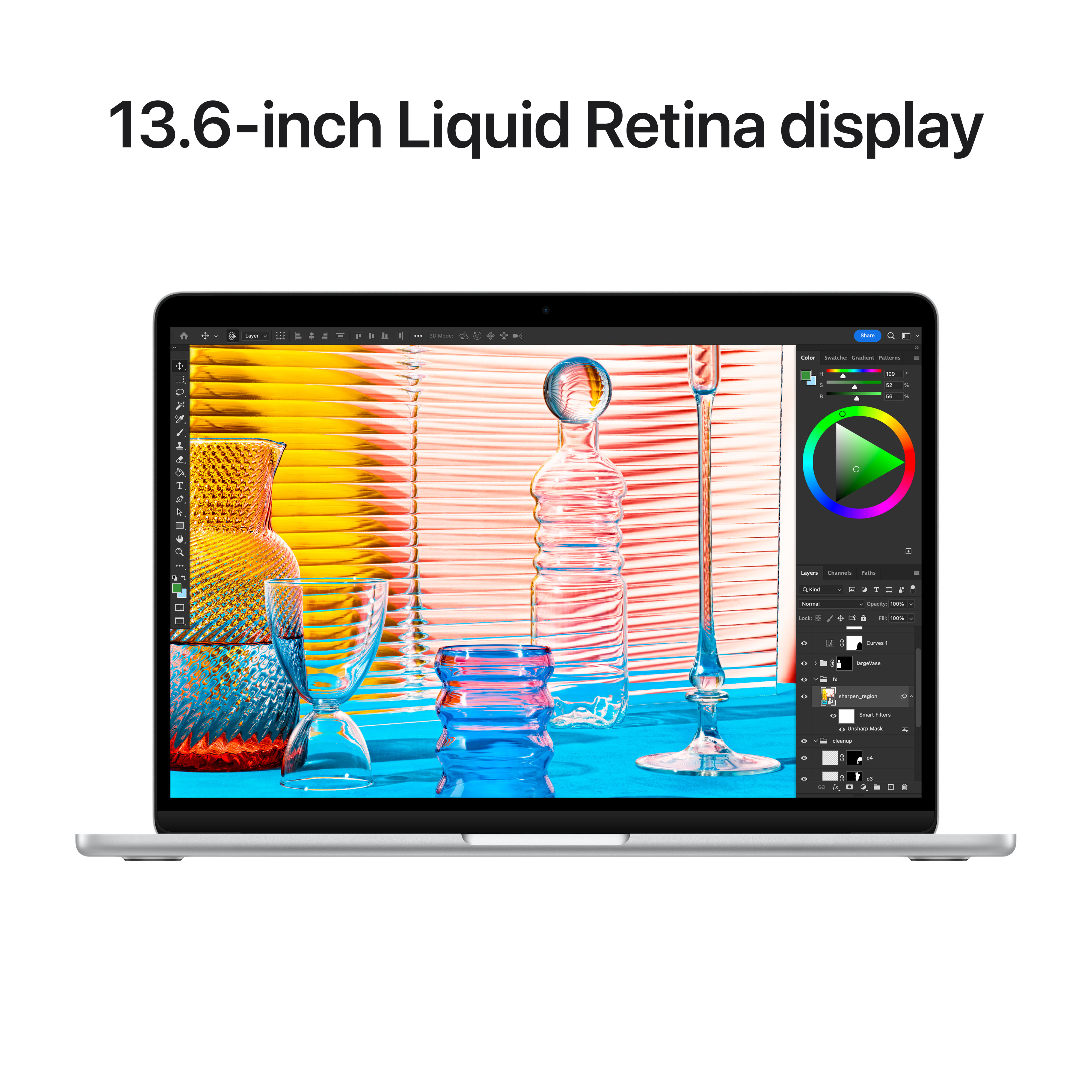Laptop pokazujący koło kolorów, szkło i inne przedmioty na stole.