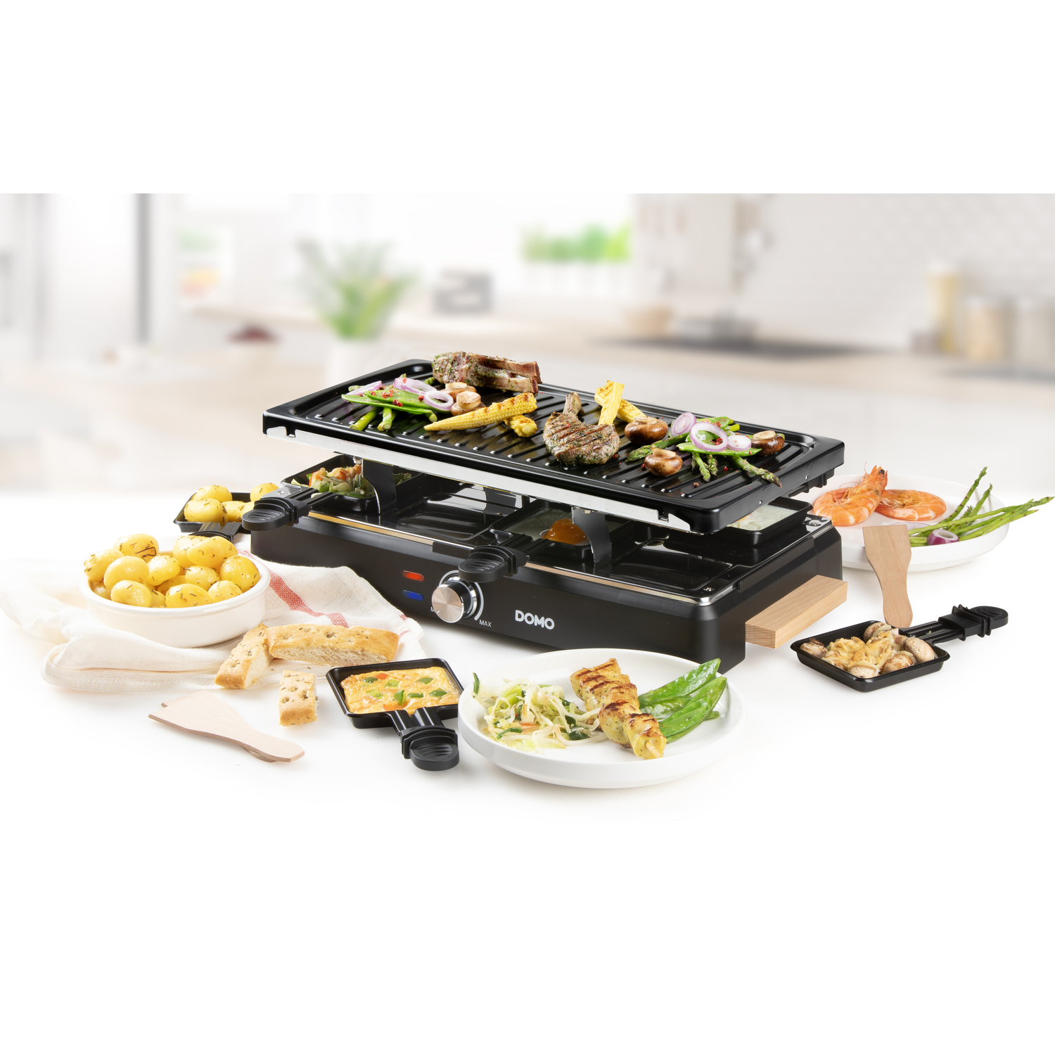 Un appareil à raclette avec des aliments et ingrédients cuits. Vue latérale.
