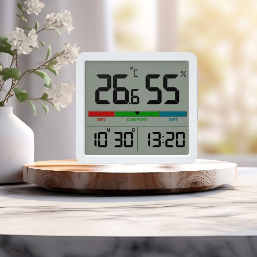 Termometr cyfrowy pokazujący 26,6°C i 55%. Drewniana podstawka na marmurowej powierzchni.