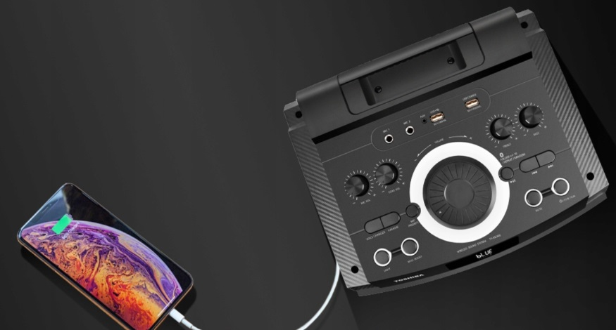 Czarny głośnik z telefonem ładującym na czarnej powierzchni. Telefon pokazuje ekran ładowania.