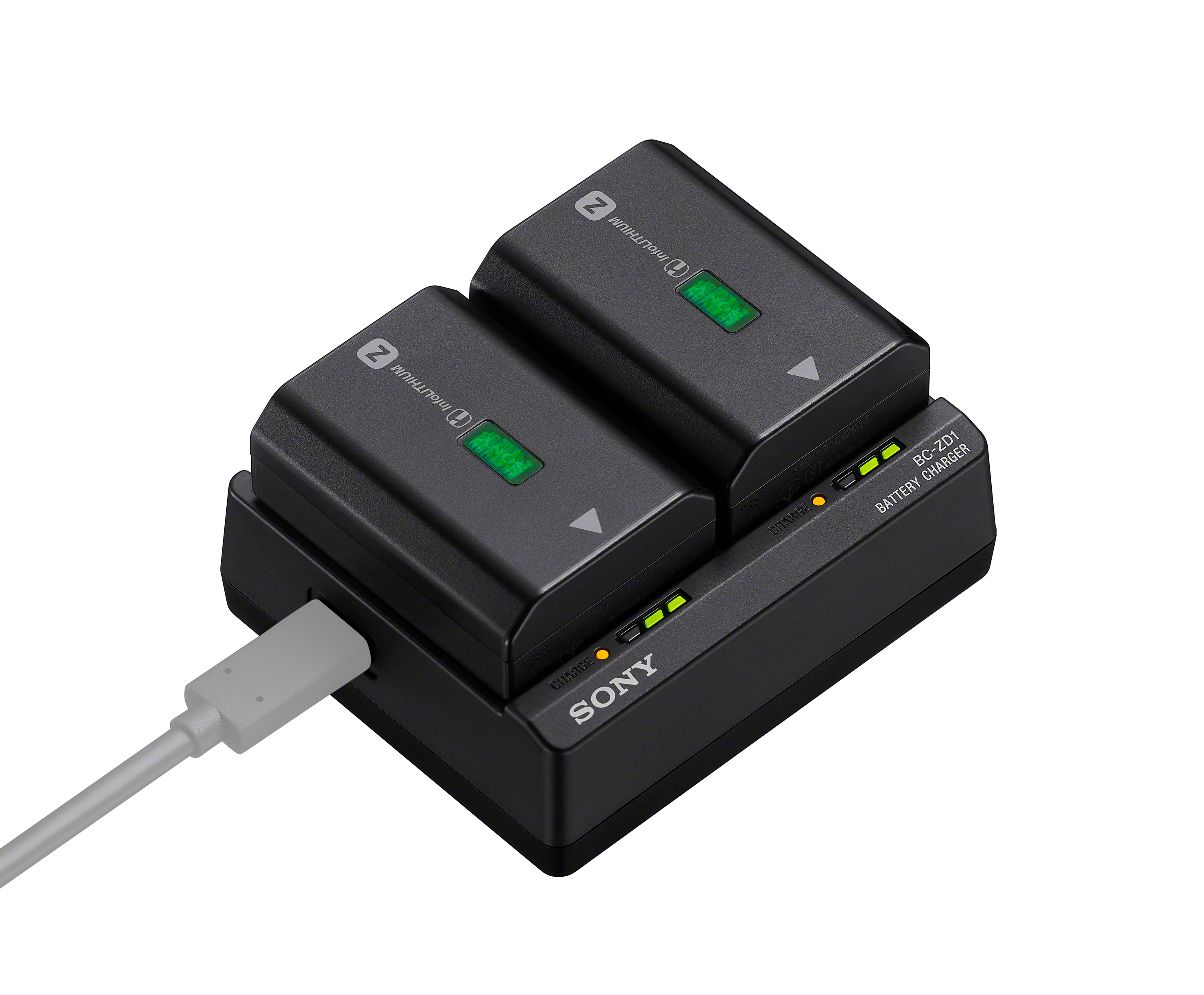 Caricabatterie Sony. Due batterie sopra. Cavo bianco collegato. Caricatore nero.