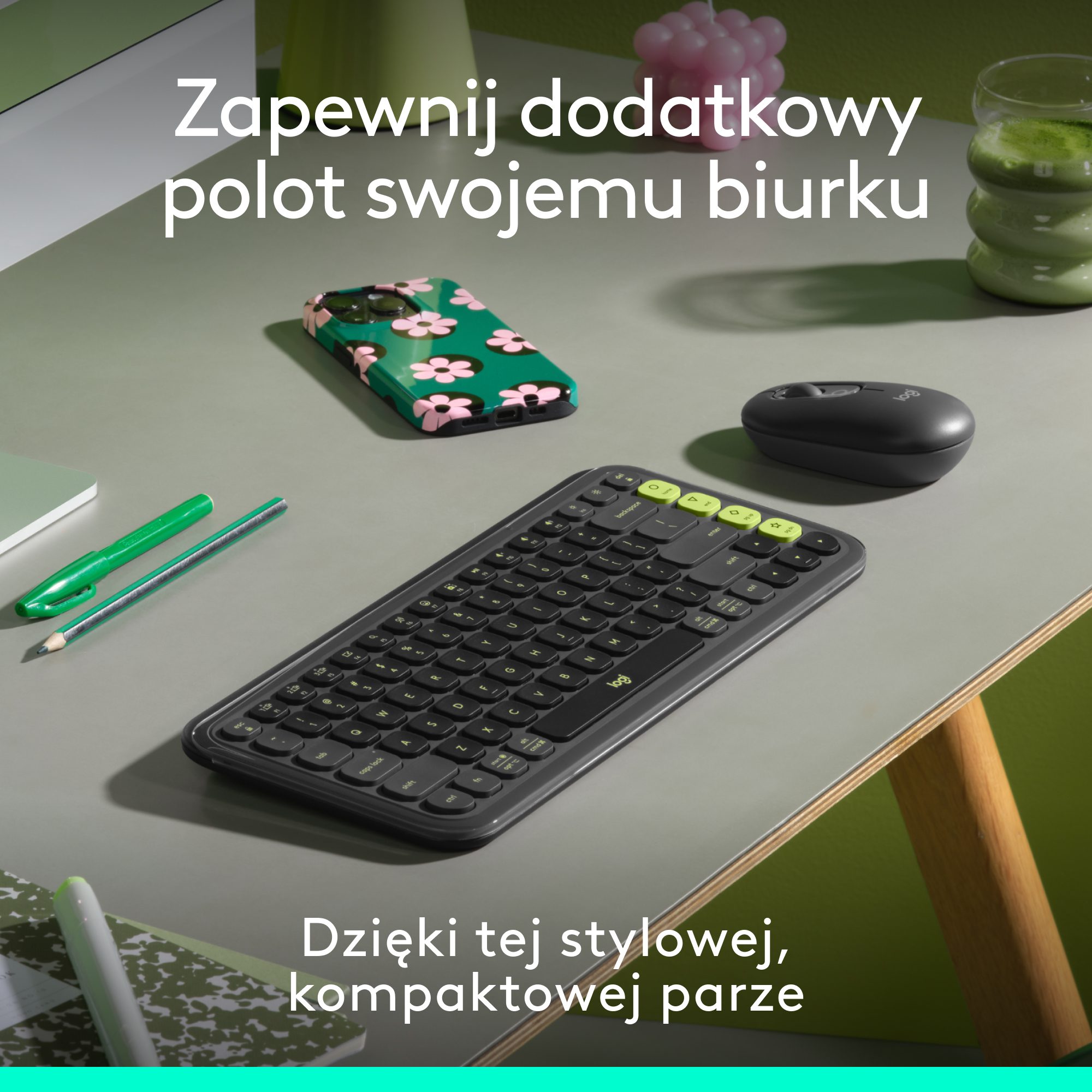 Konfiguracja biurka z klawiaturą, myszą, długopisem i etui na telefon z kwiatowym wzorem.