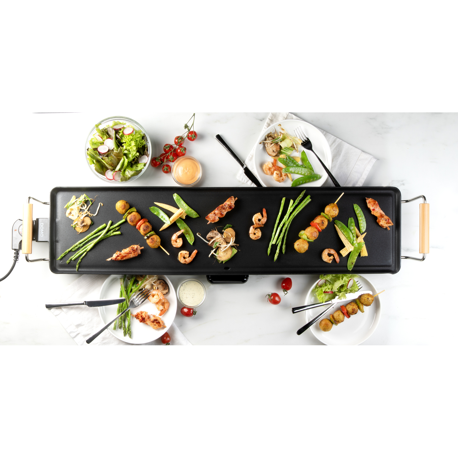 Vue aérienne d'une table avec de la nourriture, dont des brochettes, des crevettes et des légumes.