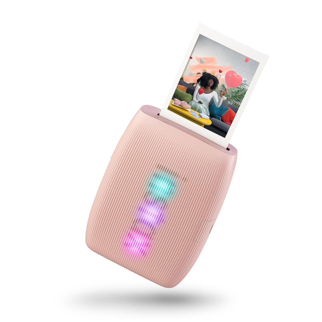 Bir kadının fotoğrafını yazdıran pembe bir anlık fotoğraf yazıcısı.
