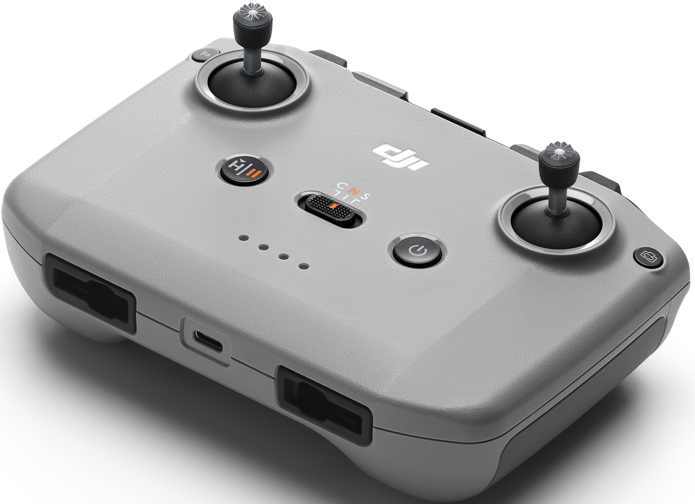 Une télécommande de drone grise avec deux joysticks, des boutons et un interrupteur central. Le logo DJI est visible.