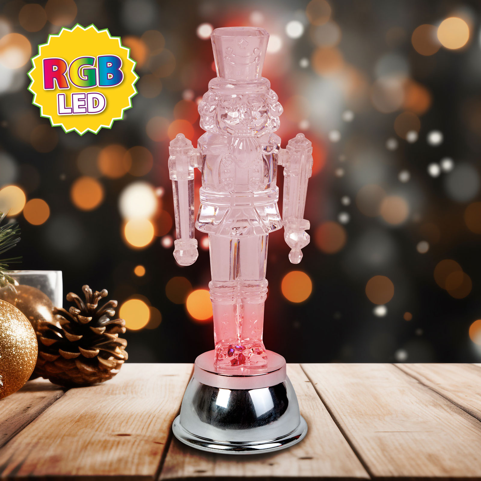 Rózsaszín RGB LED dió-törő figura fa felületen, ünnepi háttérrel.