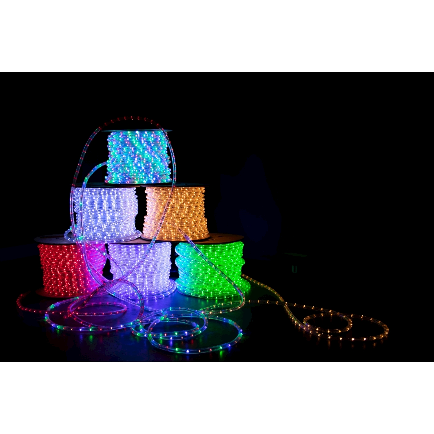 Strisce luminose a LED colorate in rotoli su una superficie nera, con fili srotolati.
