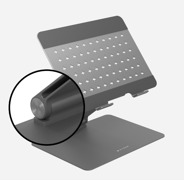 Soporte para laptop gris oscuro, con junta circular. La parte superior tiene orificios de ventilación.