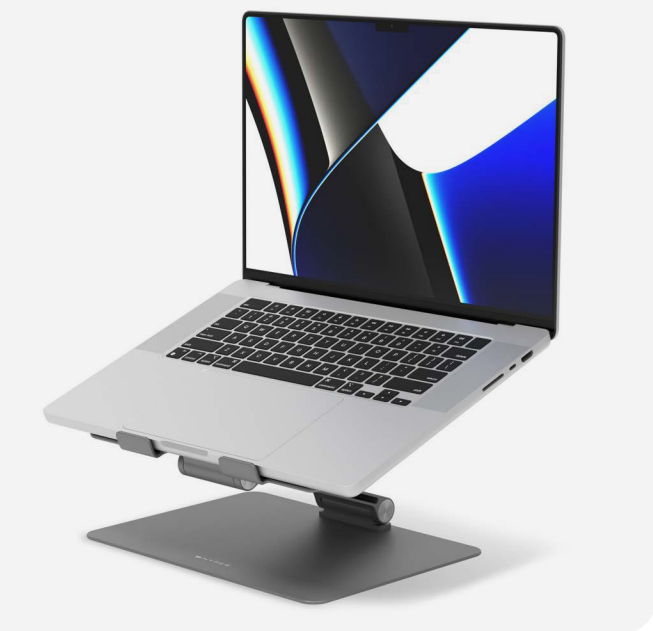Laptop plateado sobre un soporte. La pantalla muestra una imagen colorida. El soporte es gris.