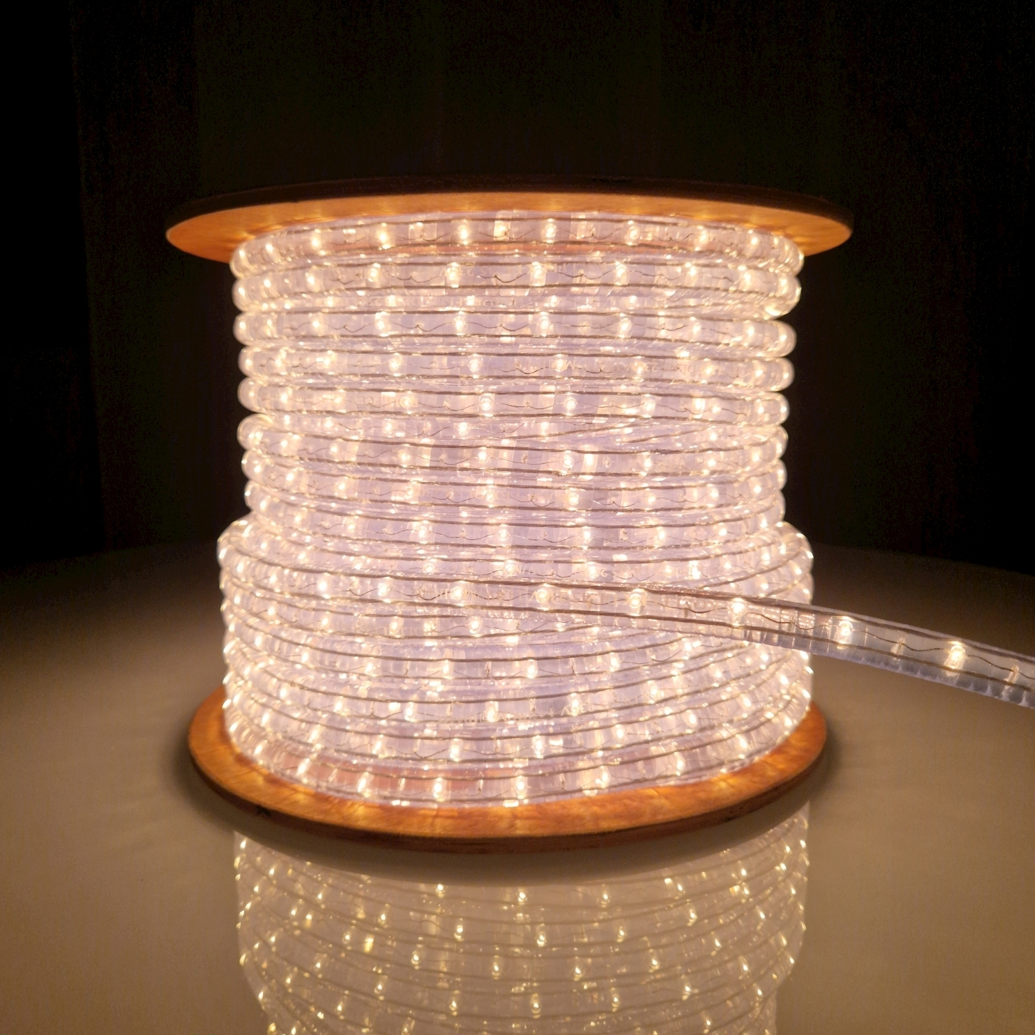 Una bobina di strisce LED bianche su base in legno, che riflette la luce.