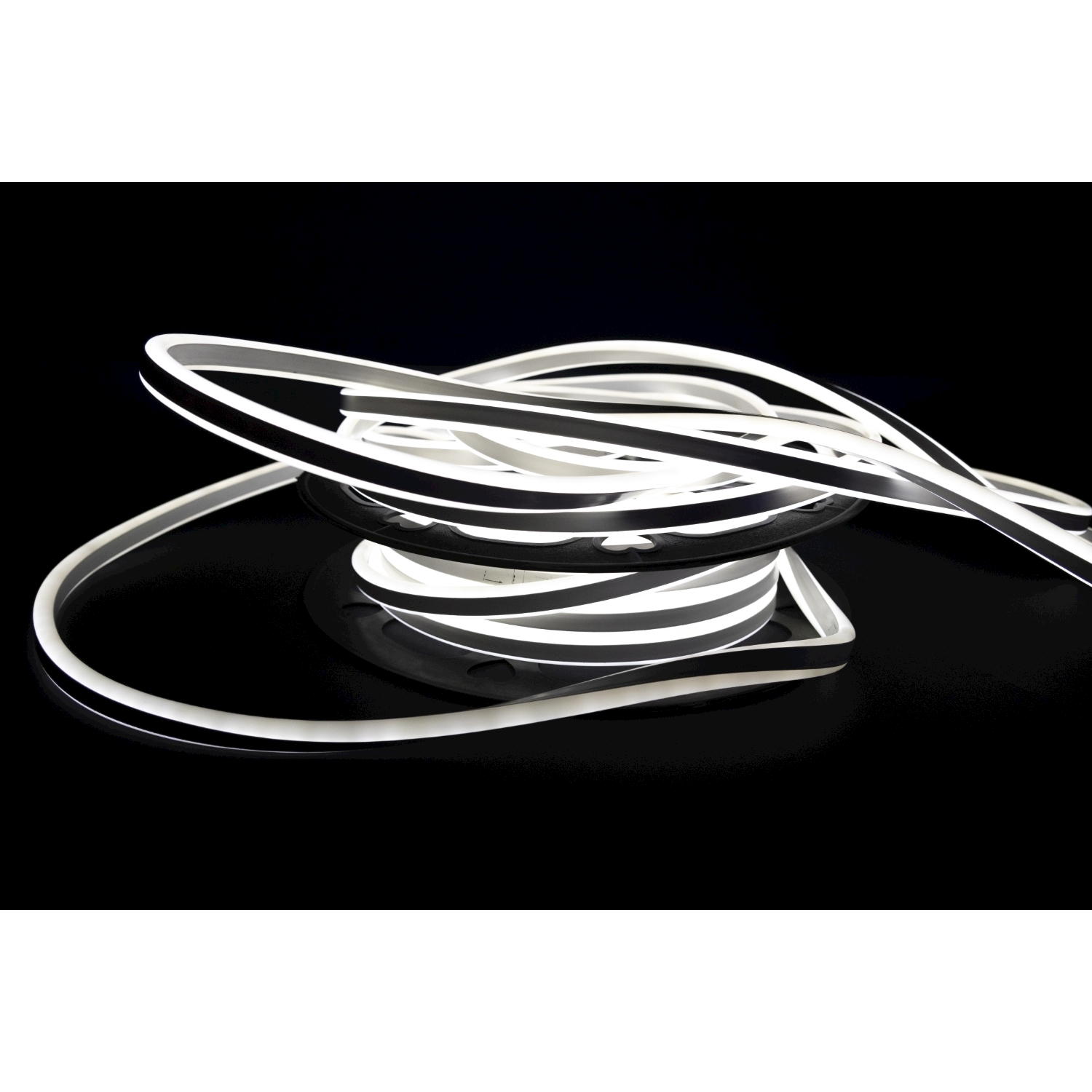 Un rotolo di luce neon flex bianca su una superficie nera.