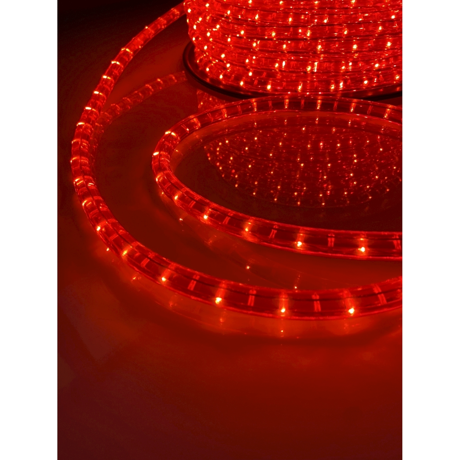 Luci a corda a LED rosse arrotolate. Luci su una superficie.