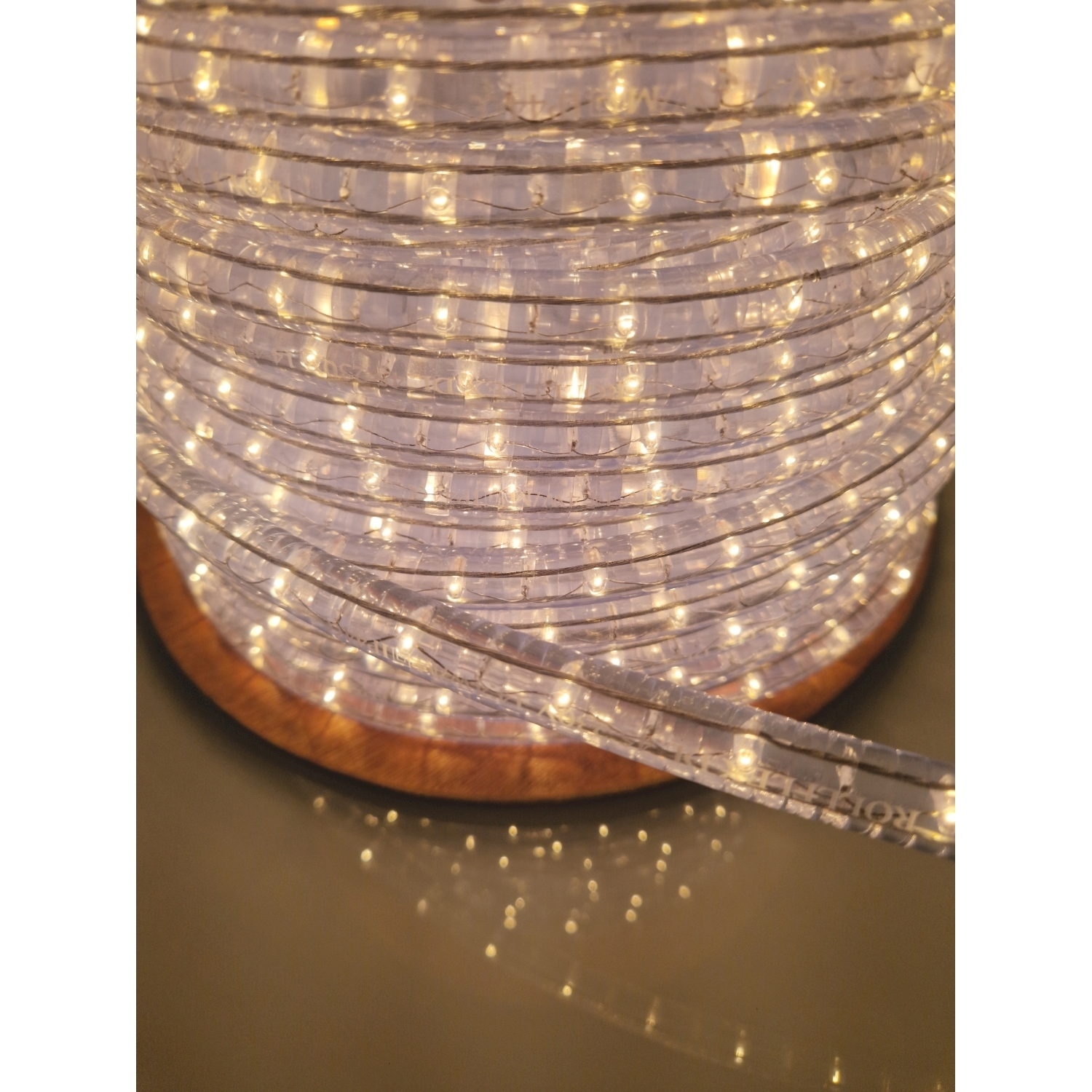 Primo piano di una fila di lucine avvolta attorno a una bobina di legno.