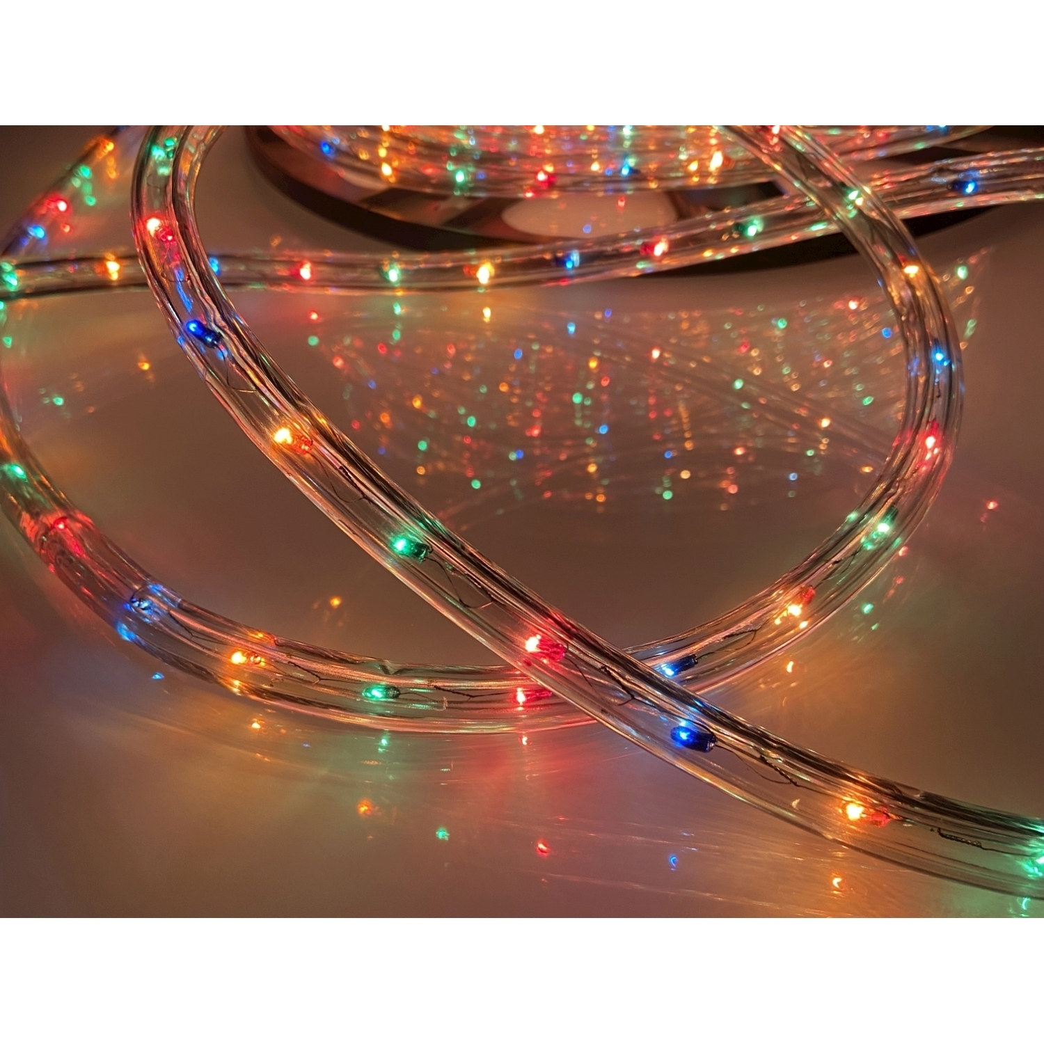 Primo piano di una stringa di luci LED colorate, con uno sfondo caldo e sfocato.