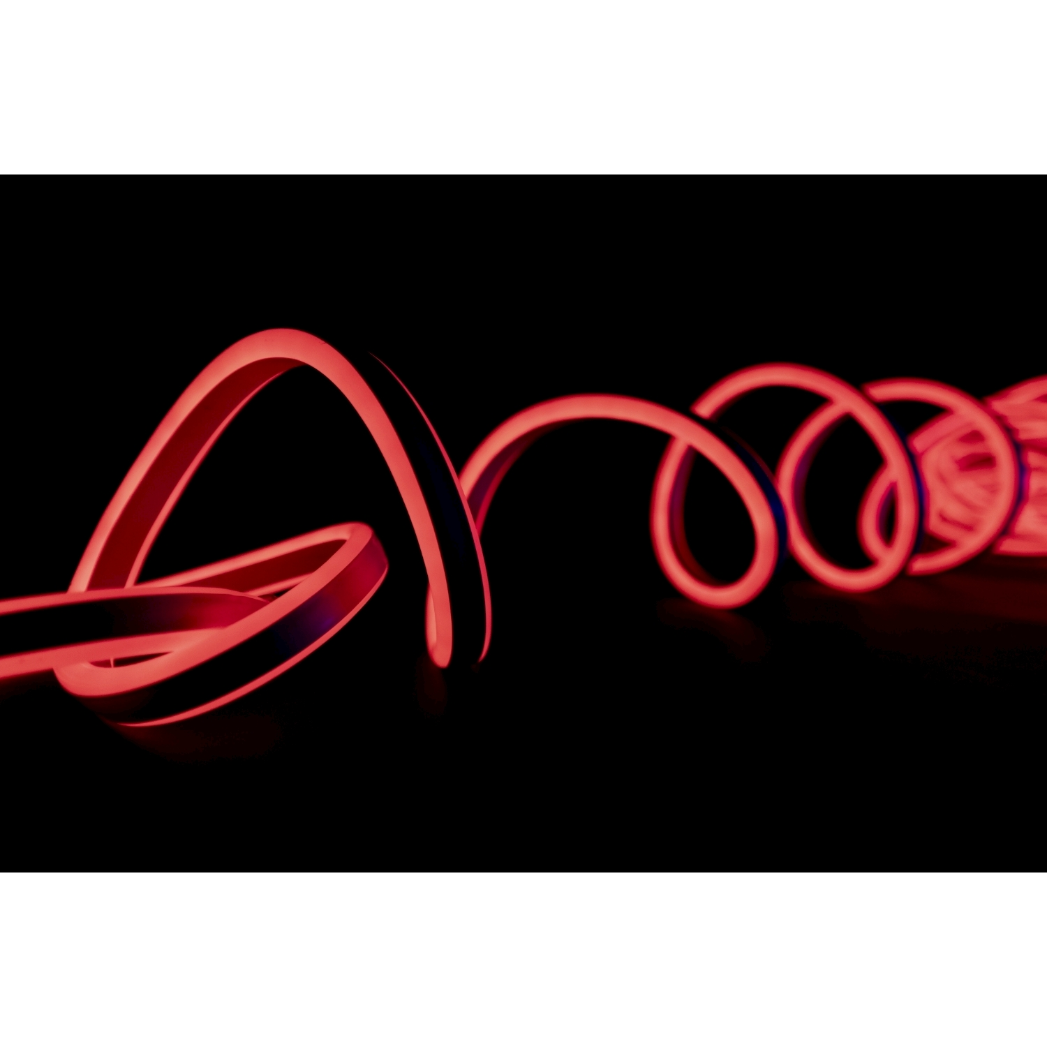 Striscia luminosa al neon rossa, arrotolata e brillante su sfondo nero, con effetto sfocato.