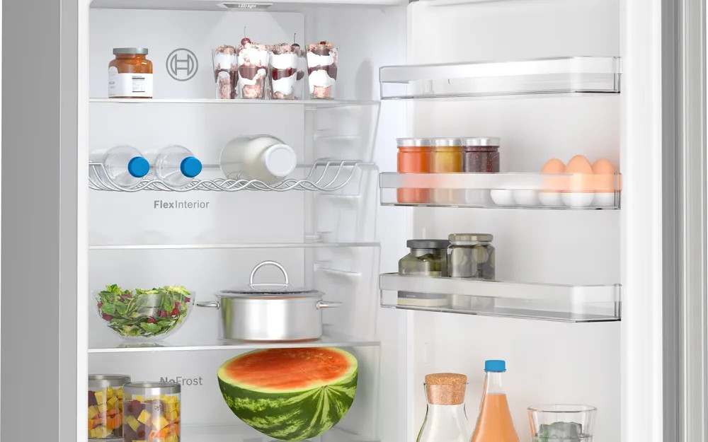 Wnętrze lodówki. Zawiera produkty spożywcze: wodę, mleko, sałatę, arbuza i słoiki.