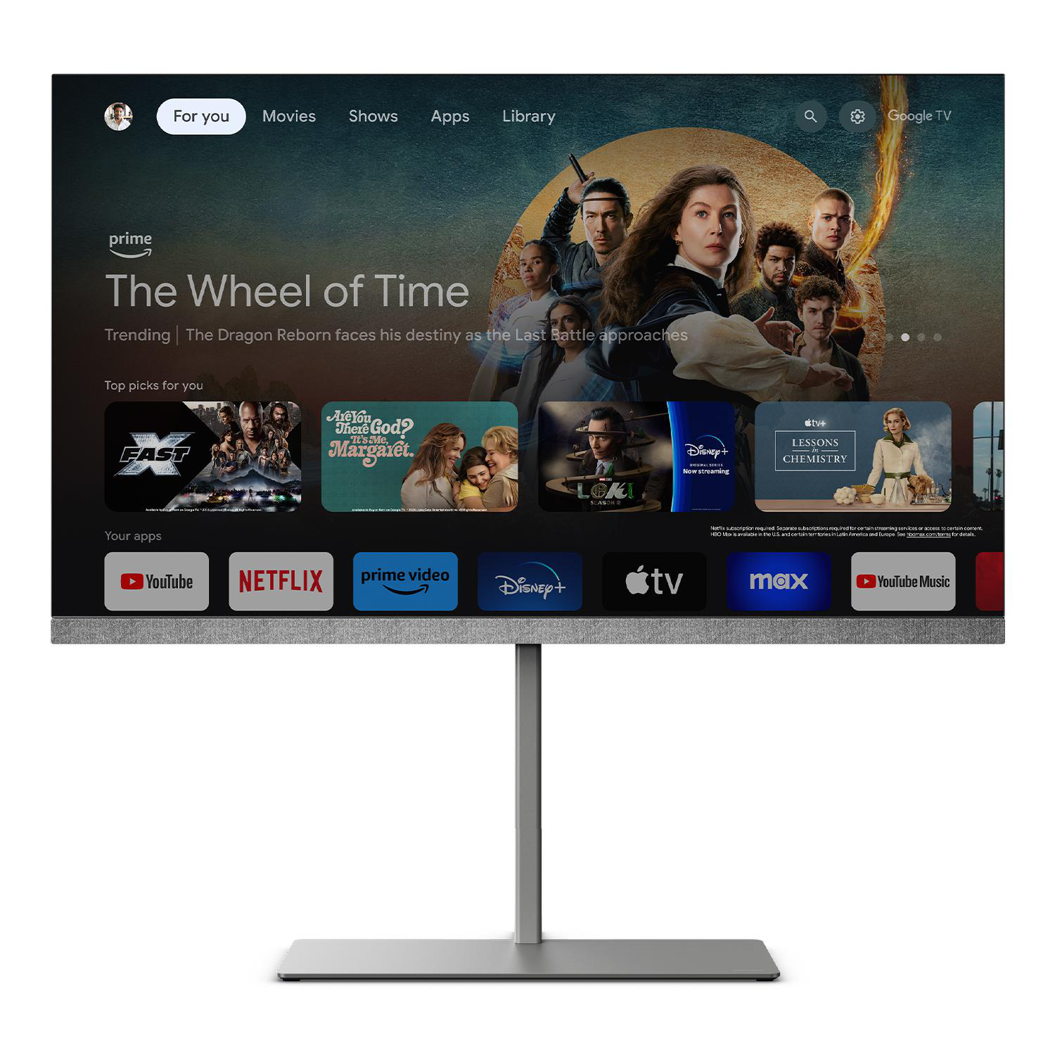 Großer Smart-TV, der eine Streaming-Dienstoberfläche anzeigt. Silberner Ständer, weißer Hintergrund. Mehrere Apps.