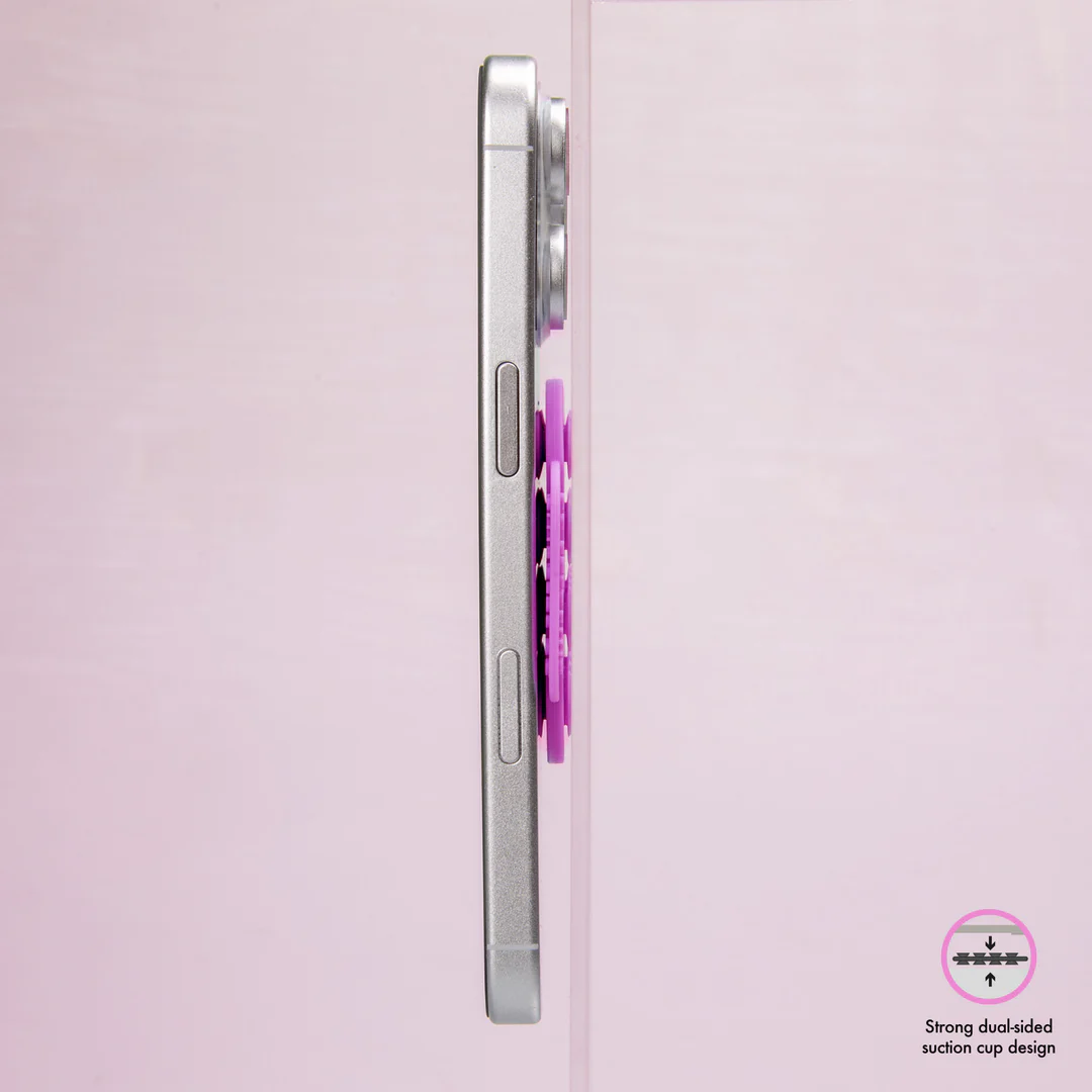 Silbernes Telefon mit lila Zubehör, das ein Saugnapfdesign zeigt. Rosa Hintergrund.