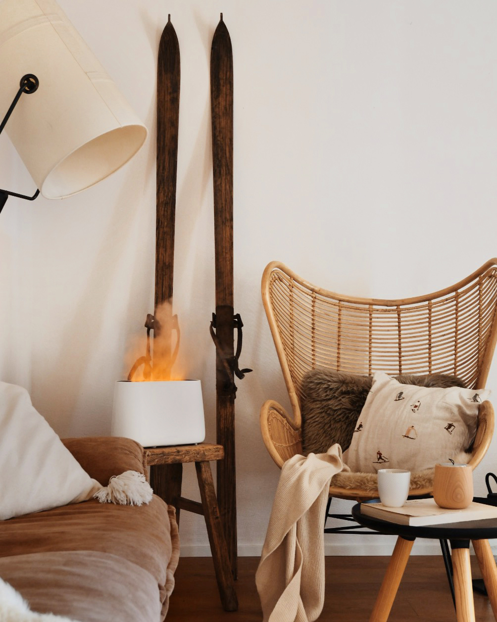 Ein Wohnzimmer mit Skiern, einem Stuhl, einer Lampe und einem Heizgerät mit Flammen.