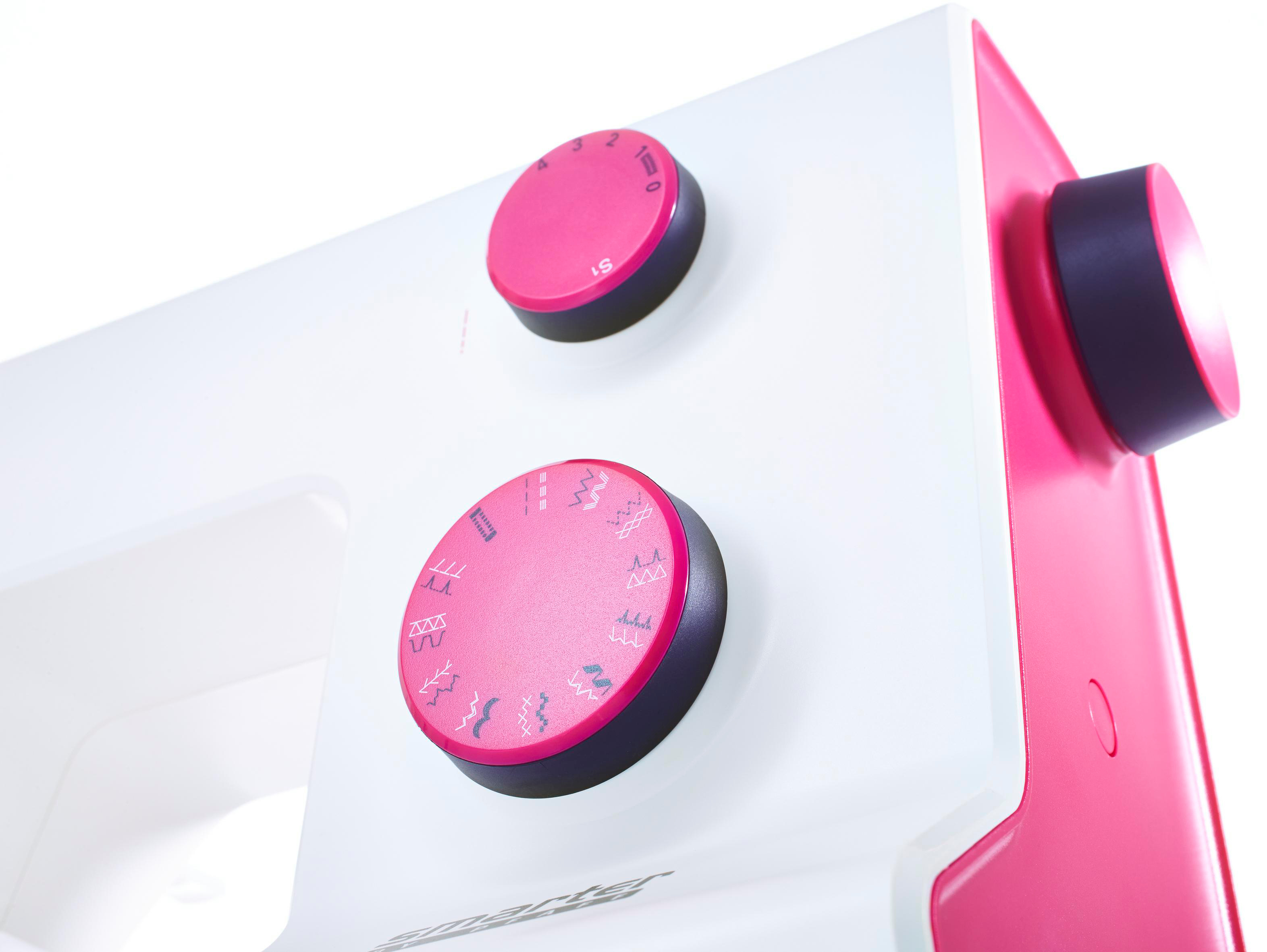 Nahaufnahme einer Nähmaschine mit rosa Knöpfen und weißem Gehäuse. Zwei rosa Knöpfe sind sichtbar. Auf weißem Hintergrund.