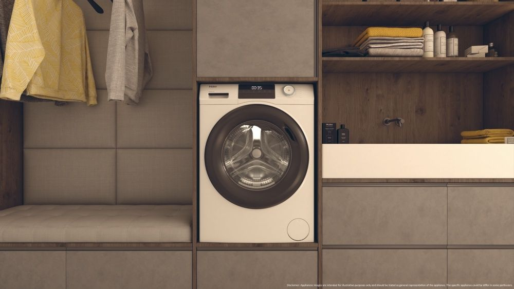 A white washing machine in a wooden cabinet, with clothes hanging on the side.