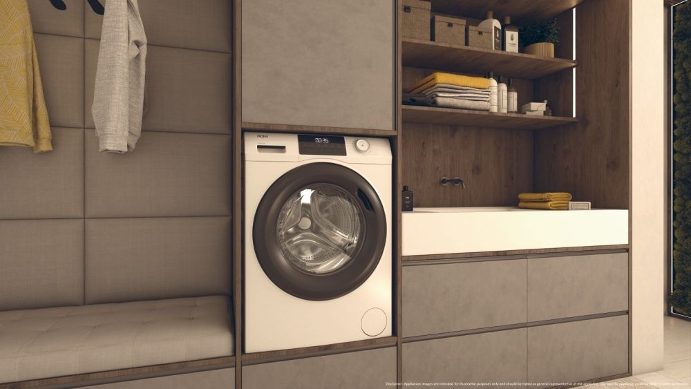 Modern laundry room with a washing machine, shelves, and cabinets in shades of gray and wood.