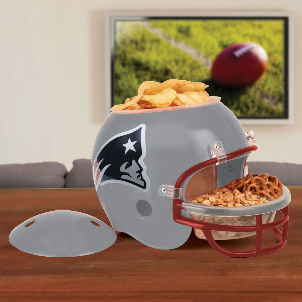 Una ciotola per snack a forma di casco da football grigia con patatine e pretzel; TV sullo sfondo.