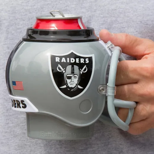 Una persona che tiene un portabicchieri a forma di casco dei Raiders. La lattina è rossa.