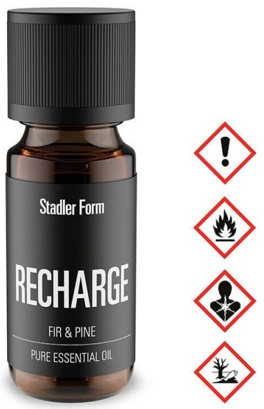 Butelka olejku eterycznego ze znakami ostrzegawczymi, tekst brzmi 'RECHARGE' i 'FIR & PINE'.