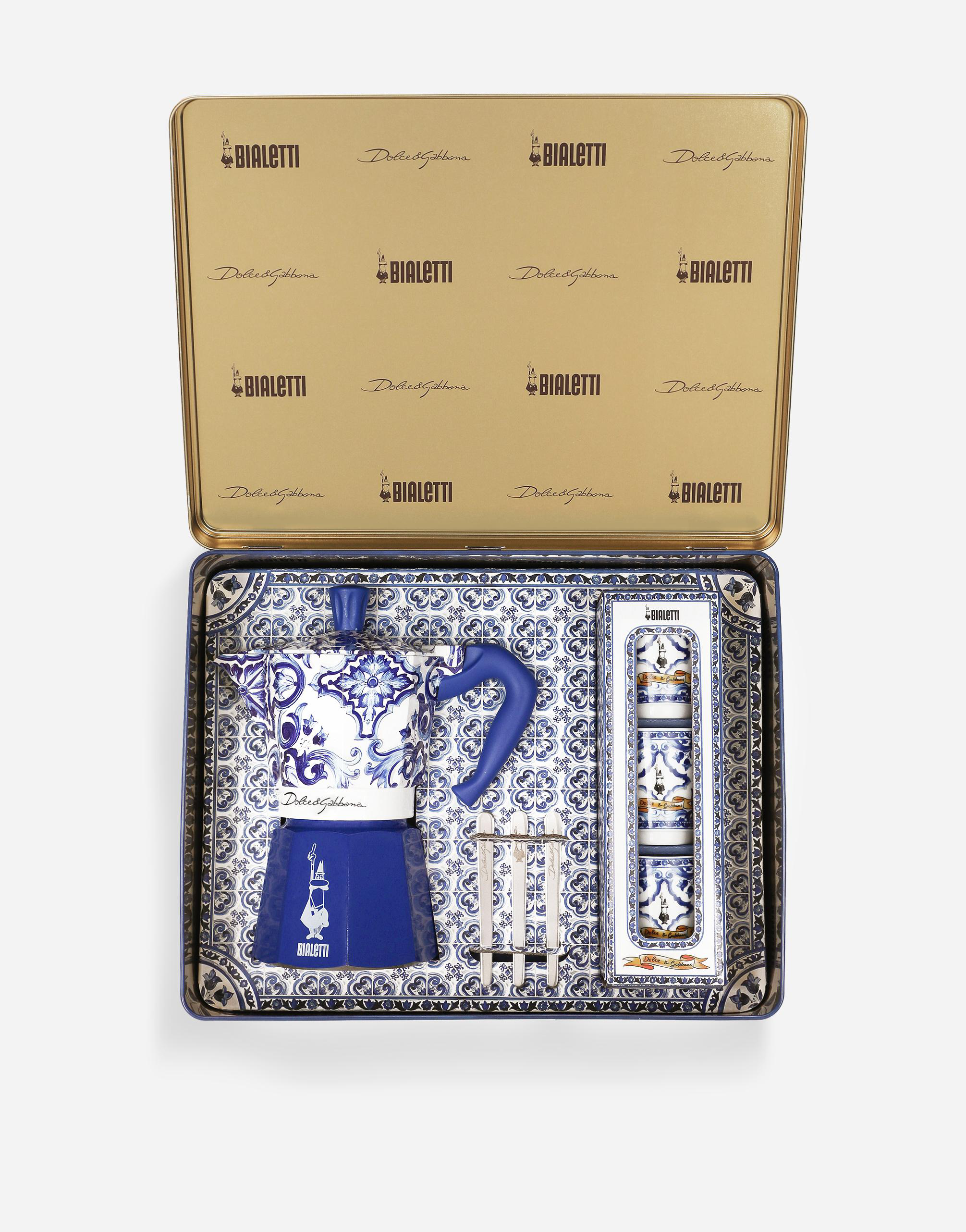 Ein Bialetti-Kaffeemaschinen-Set in einer dekorativen Dose, mit Tassen und Ständer, zeigt blau-weiße Muster.