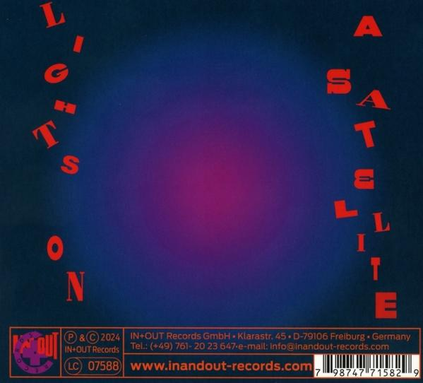 Albumcover mit dem Titel 'Lights on a Satellite'. Text in Rot und Weiß auf blau-violettem Hintergrund.