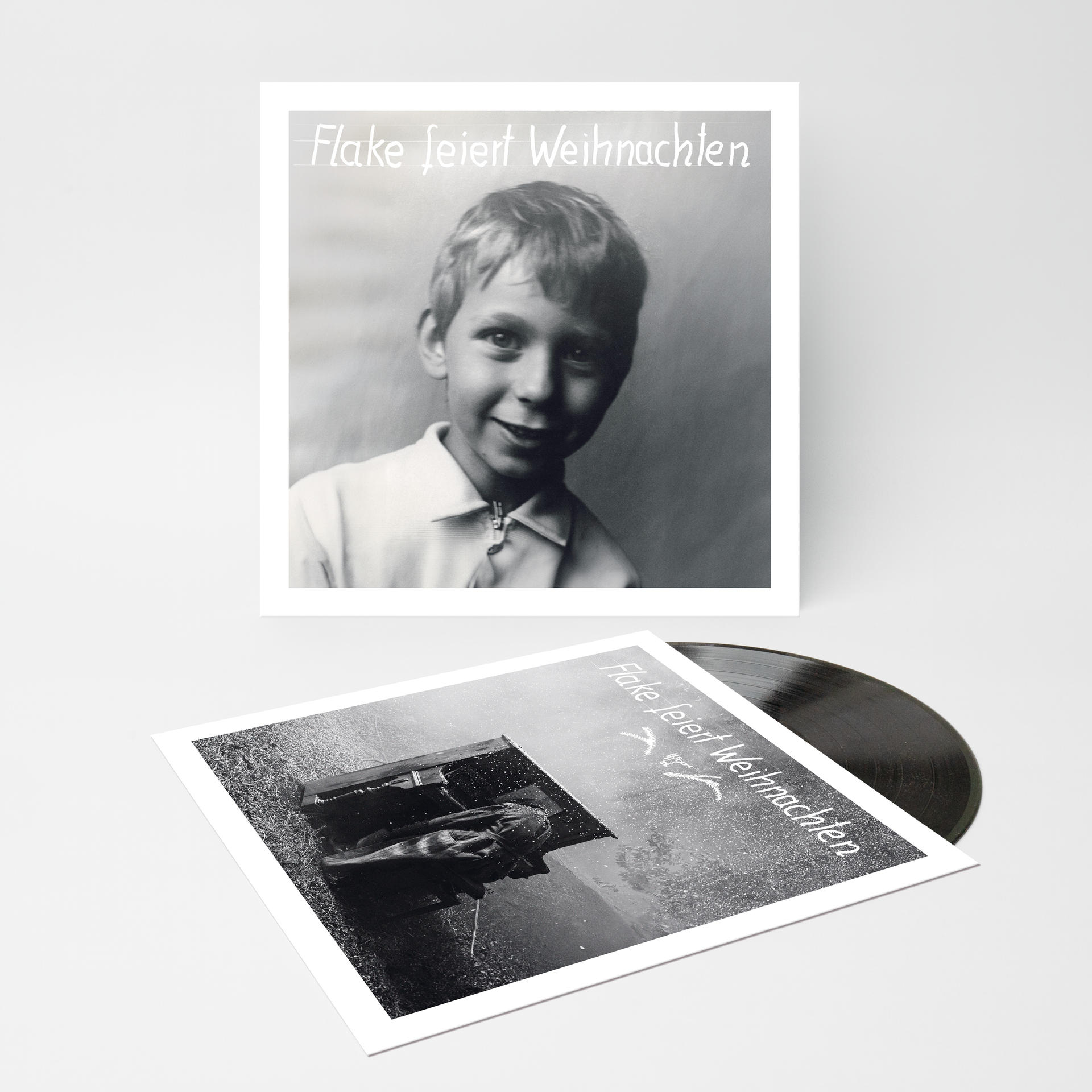 Zwei Schallplatten auf weißer Oberfläche. Die obere ist ein Cover mit einem Jungen.