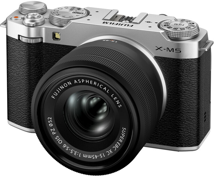 Ezüst-fekete Fujifilm X-M5 fényképezőgép objektívvel, fehér háttéren.