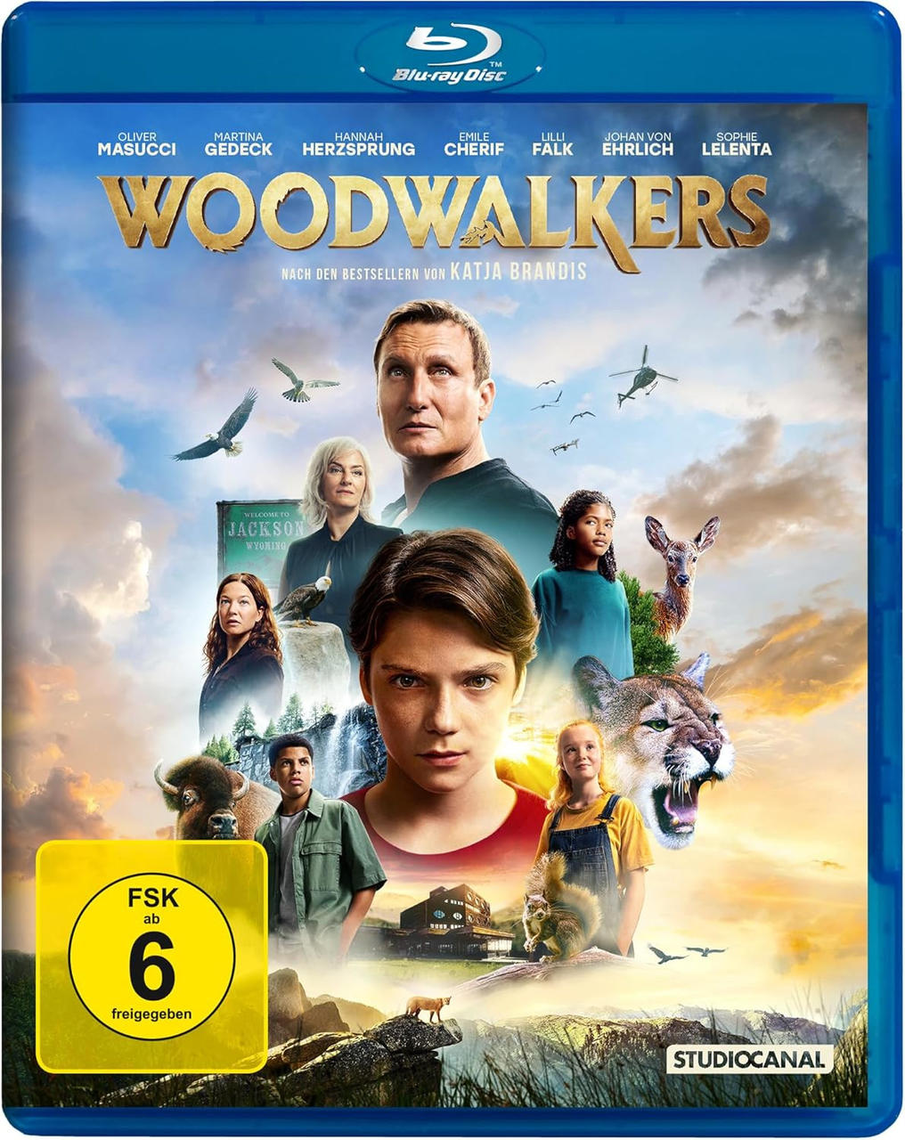 Blu-ray Disc des Films 'WOODWALKERS'. Zeigt Schauspieler und eine Waldszene mit Tieren.