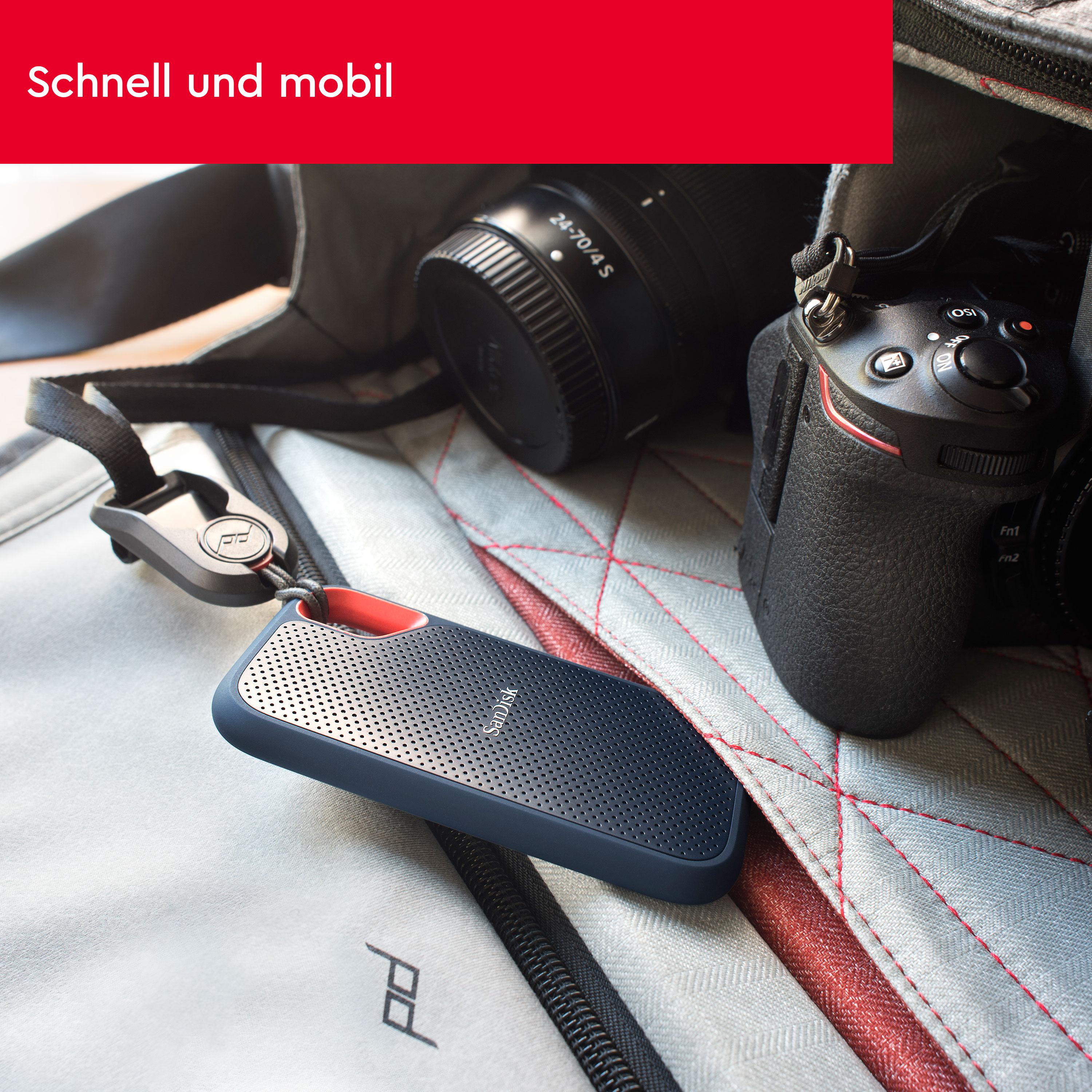 Eine tragbare Festplatte neben einer Kamera und einer Tasche.