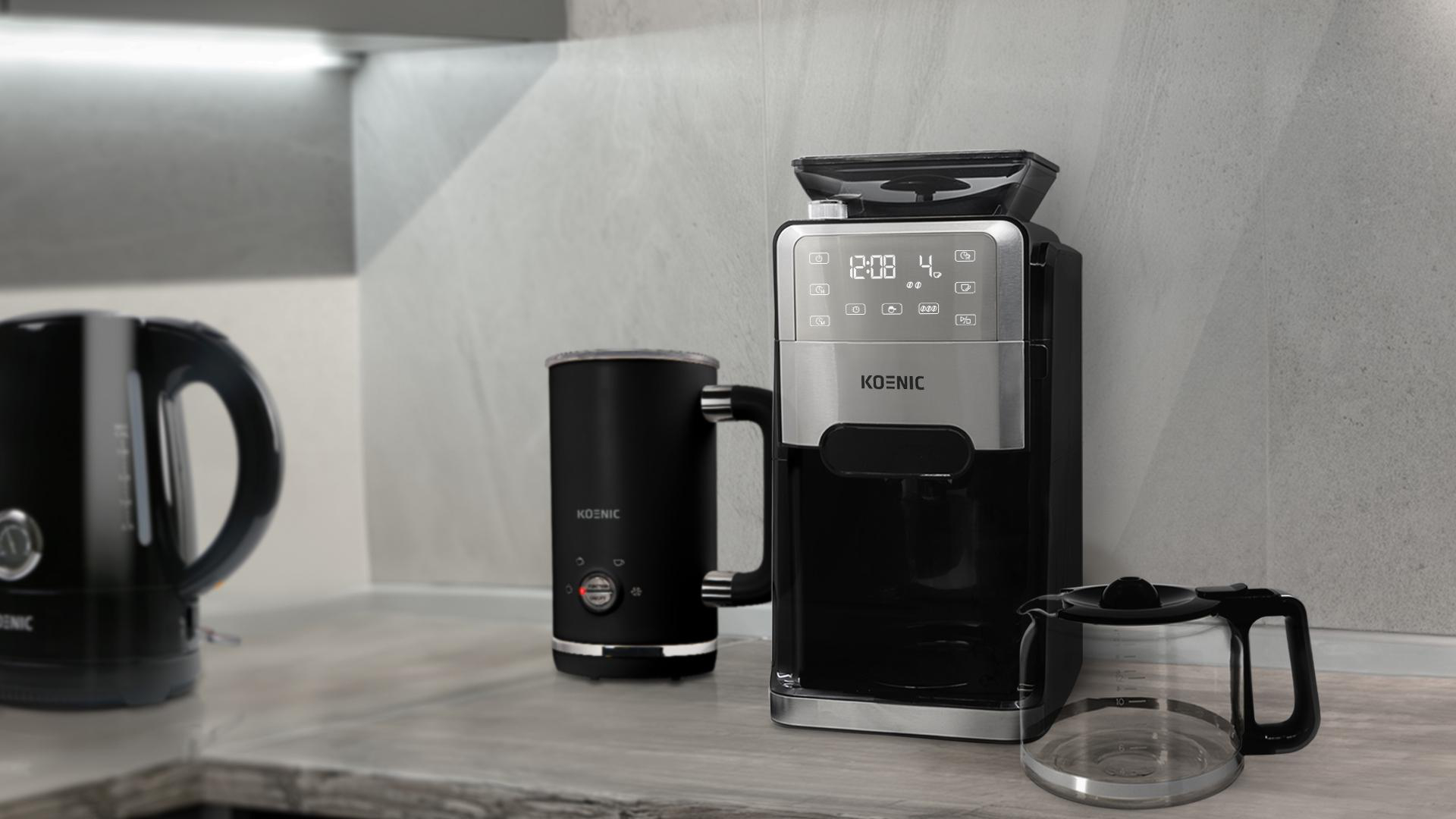 Eine Küchenzeile mit Kaffeemaschine, Wasserkocher und Milchaufschäumer, alles schwarz.