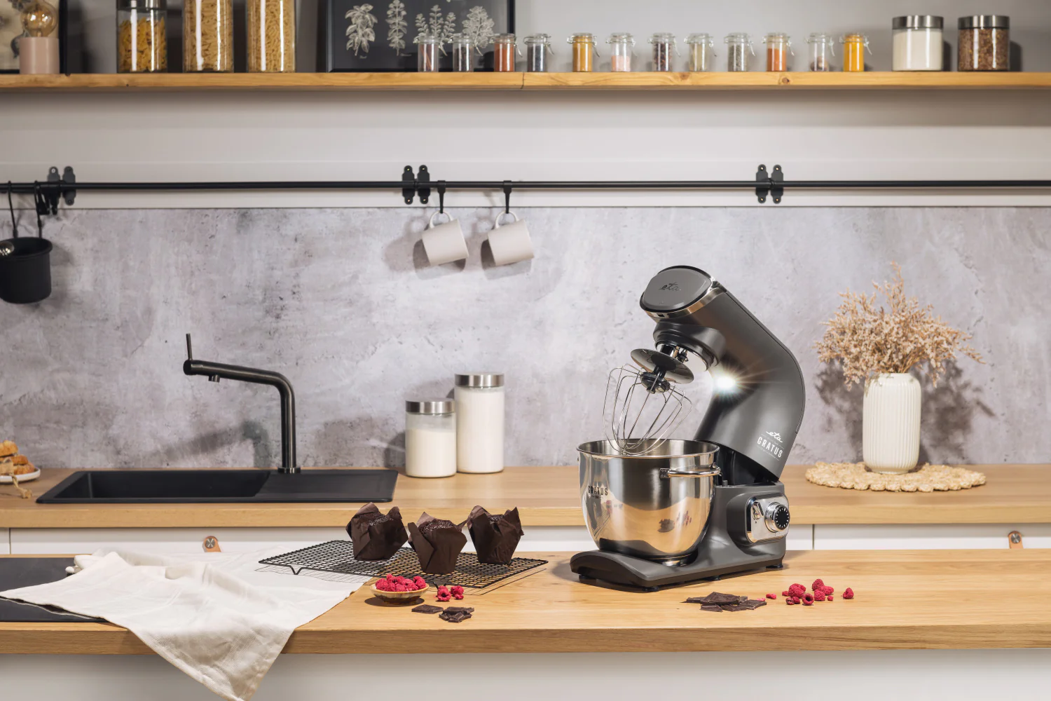 Konyhai jelenet konyhai robotgéppel, muffinokkal és hozzávalókkal. Fa pult és polcok.
