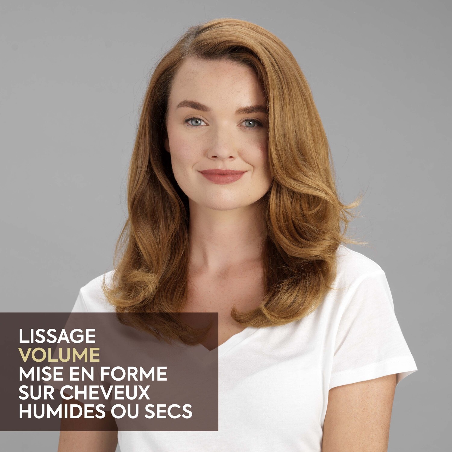 Woman with long, wavy auburn hair, wearing a white shirt, with a gray background and text overlay.