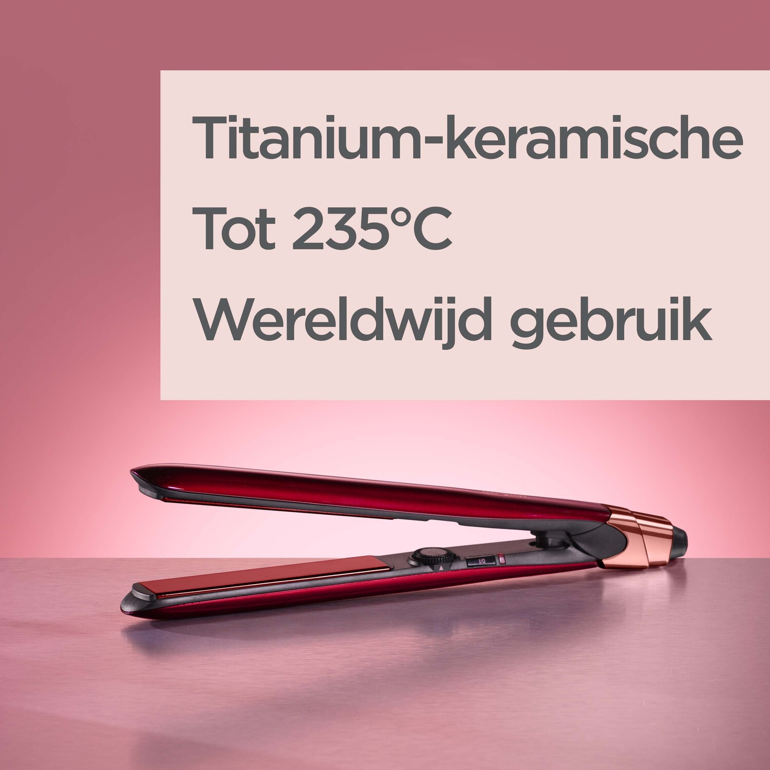 A red hair straightener with text in Dutch on a pink background and a rose gold finish.